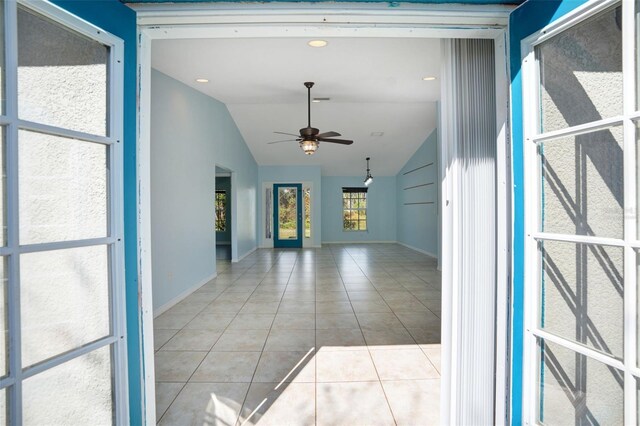 interior space featuring light tile patterned flooring, ceiling fan, and lofted ceiling