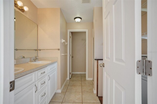 bathroom featuring vanity, a textured ceiling, and tile patterned flooring