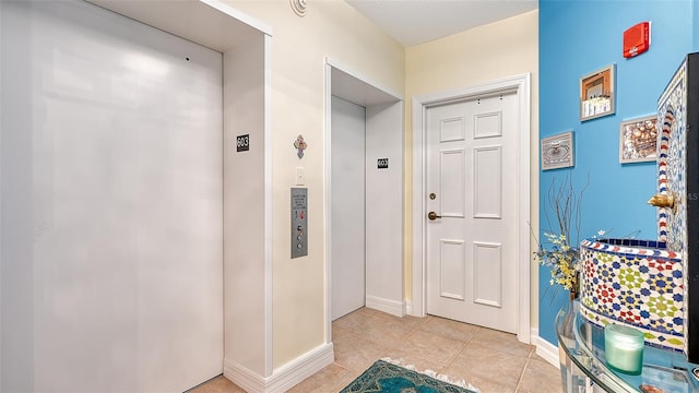 interior space with elevator and light tile patterned floors