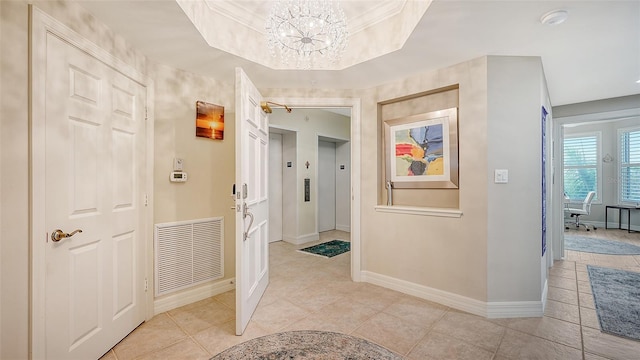 hallway with elevator, ornamental molding, light tile patterned floors, an inviting chandelier, and a raised ceiling