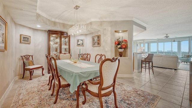 tiled dining space with a textured ceiling, ornamental molding, and ceiling fan with notable chandelier