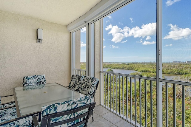 sunroom featuring a water view