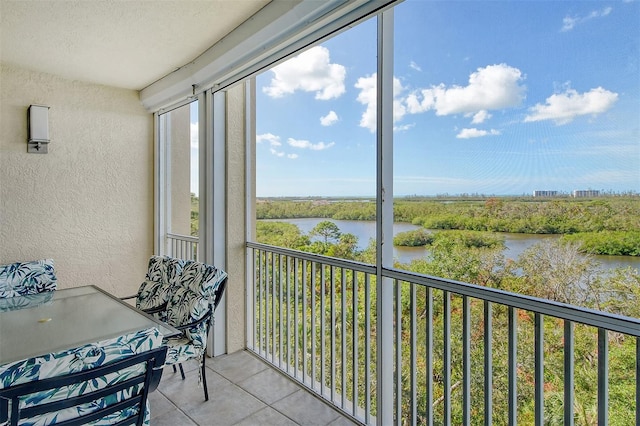 sunroom featuring a water view