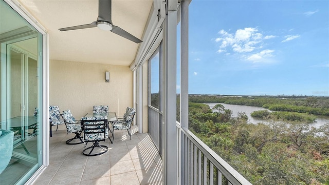 balcony with a water view and ceiling fan