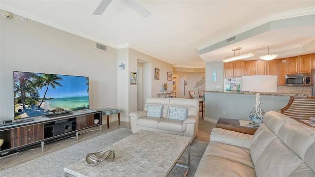 tiled living room featuring ceiling fan and crown molding