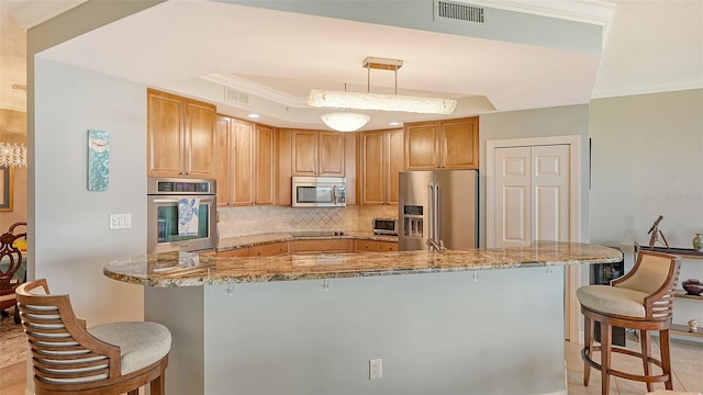 kitchen with hanging light fixtures, light stone counters, a kitchen breakfast bar, and stainless steel appliances