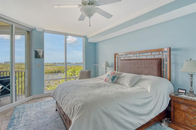 bedroom with access to outside, light wood-type flooring, and multiple windows