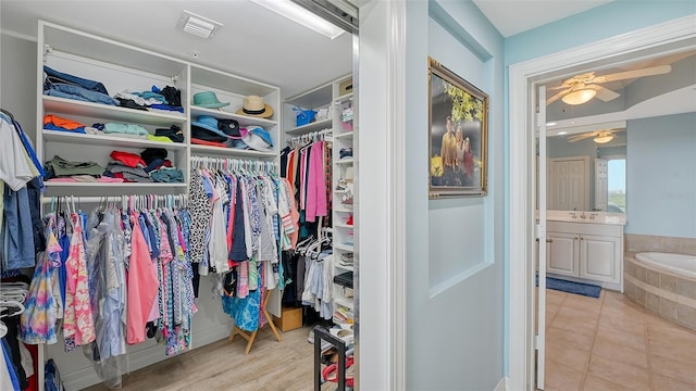 walk in closet featuring light tile patterned flooring and ceiling fan