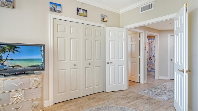 bedroom featuring light hardwood / wood-style floors, a closet, and ornamental molding