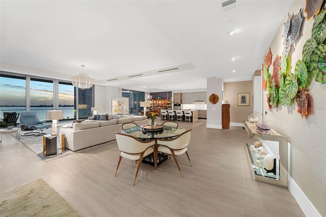 dining area with a water view and an inviting chandelier