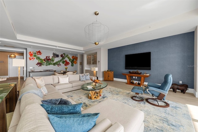 living room featuring light hardwood / wood-style flooring and a raised ceiling