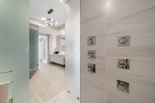 bathroom featuring vanity, tile walls, walk in shower, and hardwood / wood-style floors