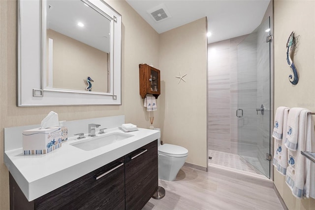 bathroom with vanity, toilet, walk in shower, and hardwood / wood-style floors