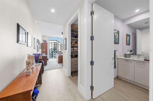 hall with sink and light wood-type flooring