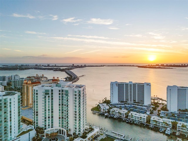 aerial view at dusk featuring a water view