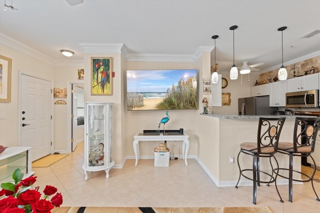 4802 51st St W Unit 1010, Bradenton, FL 34210 - kitchen with stainless steel appliances, light tile patterned floors, a kitchen breakfast bar, crown molding, and ceiling fan