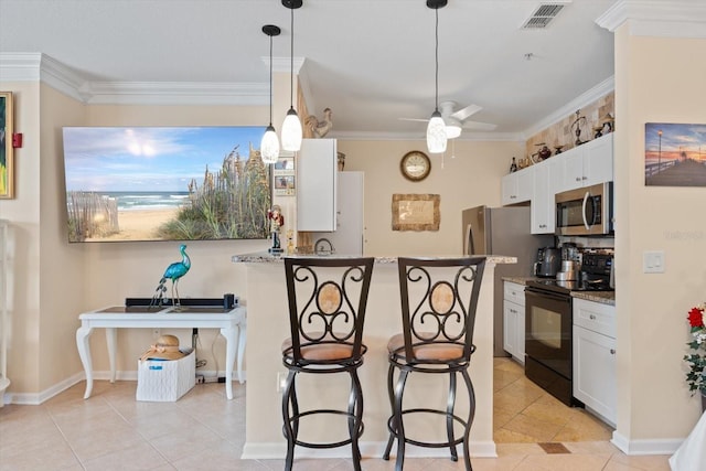 kitchen with white cabinets, light stone countertops, a kitchen bar, ornamental molding, and stainless steel appliances