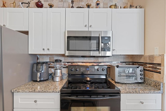 kitchen featuring white cabinetry, white fridge, black range with electric stovetop, and backsplash