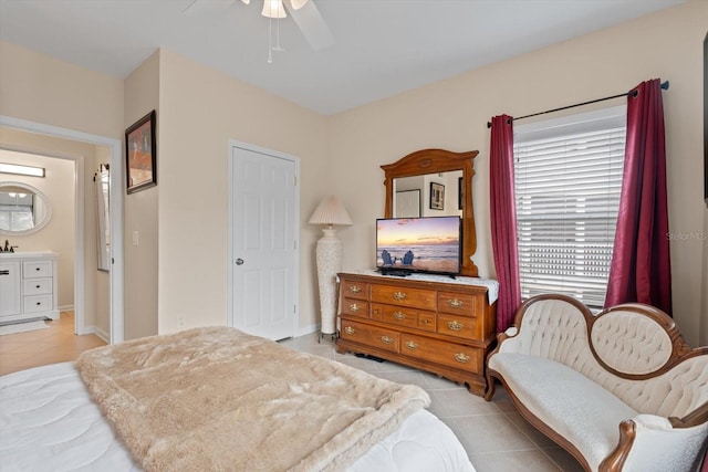 bedroom with ensuite bathroom, light tile patterned floors, and ceiling fan