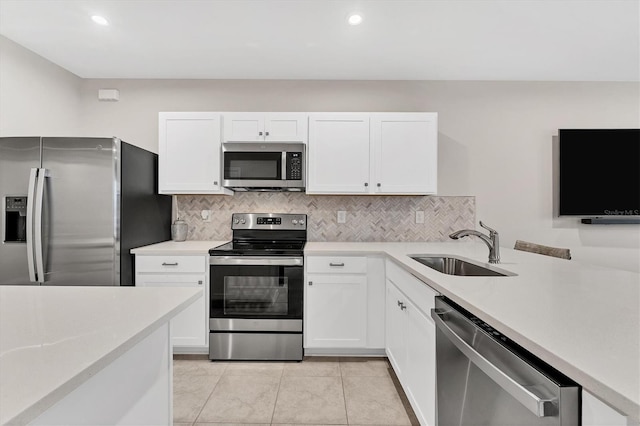 kitchen with white cabinetry, appliances with stainless steel finishes, sink, and light tile patterned flooring