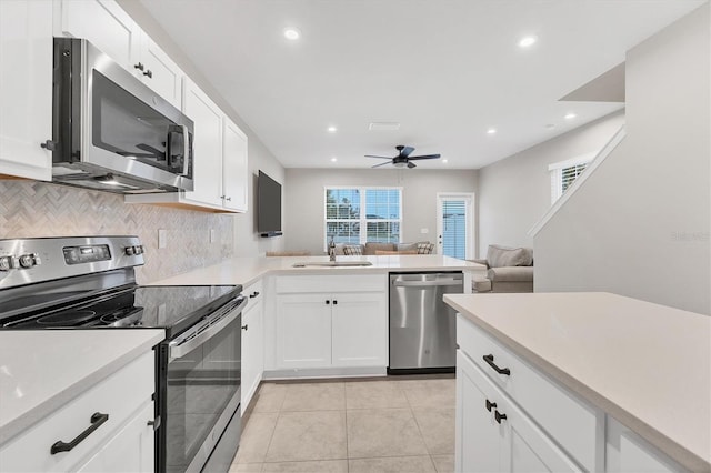 kitchen featuring white cabinetry, appliances with stainless steel finishes, sink, and kitchen peninsula