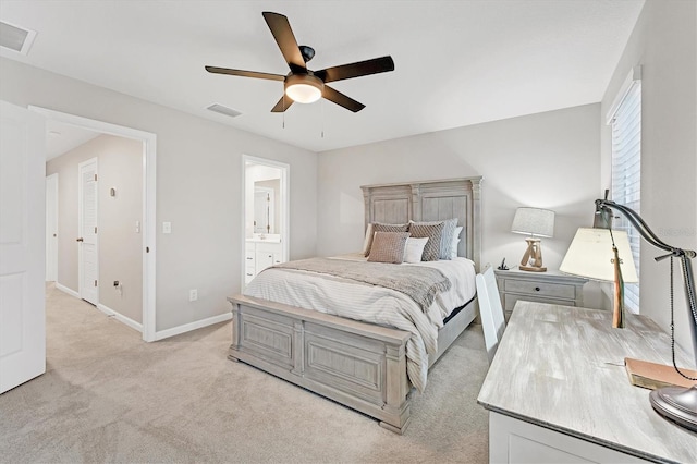 bedroom with light carpet, ceiling fan, and ensuite bath