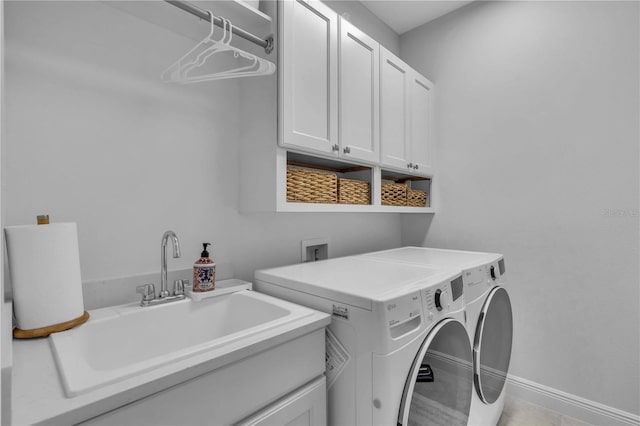 washroom with sink, light tile patterned floors, washing machine and dryer, and cabinets