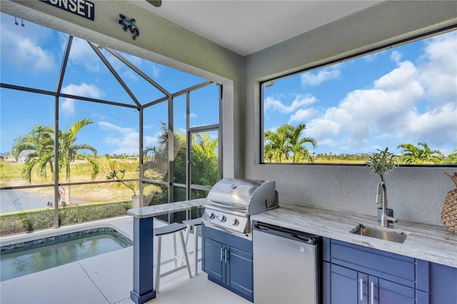 view of patio with a lanai, grilling area, and sink