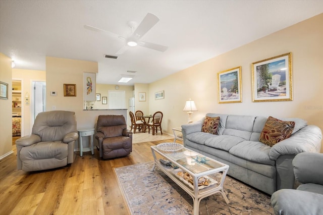 living room with light hardwood / wood-style flooring and ceiling fan