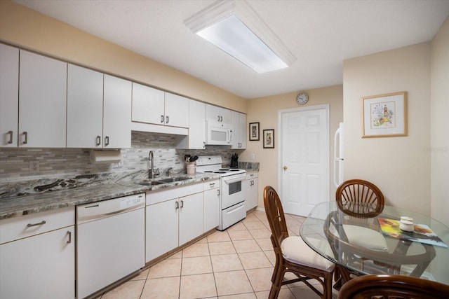 kitchen with decorative backsplash, white cabinets, sink, and white appliances