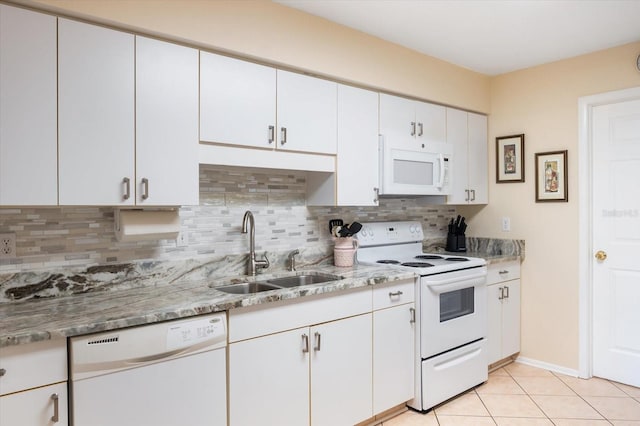 kitchen featuring decorative backsplash, sink, light tile patterned floors, white cabinetry, and white appliances