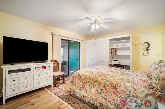 bedroom with a textured ceiling, access to exterior, hardwood / wood-style flooring, and ceiling fan