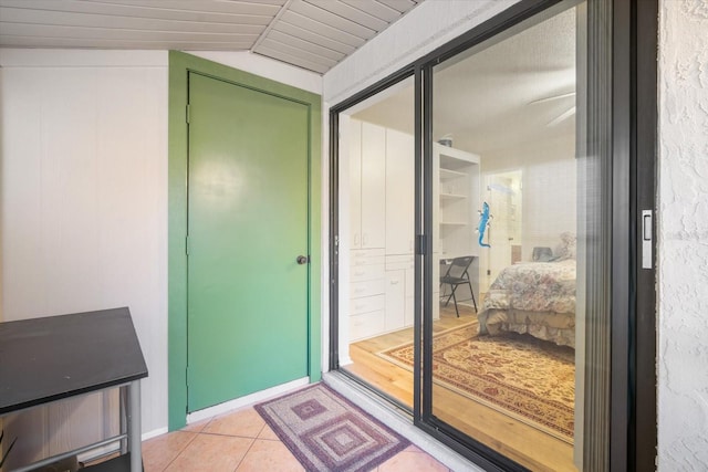 doorway to outside featuring light tile patterned flooring and vaulted ceiling