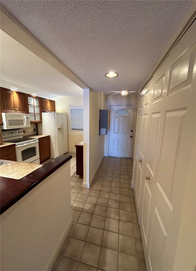 hall featuring light tile patterned floors, a textured ceiling, and electric panel