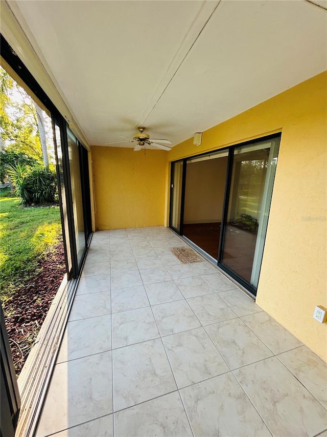 unfurnished sunroom featuring ceiling fan