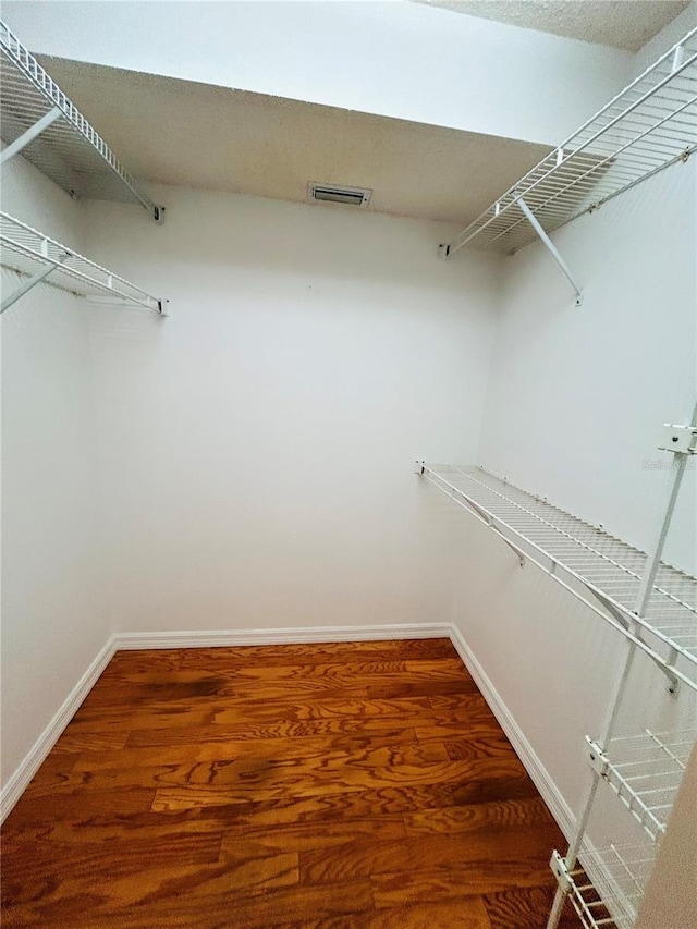 walk in closet with hardwood / wood-style floors