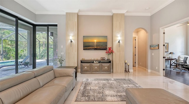 living area featuring arched walkways, crown molding, and baseboards