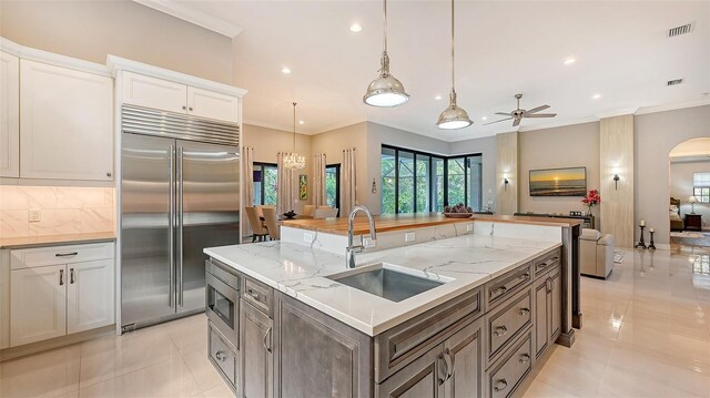 9291 Swaying Branch Rd, Sarasota, FL 34241 - kitchen with built in appliances, a sink, recessed lighting, backsplash, and a kitchen island with sink