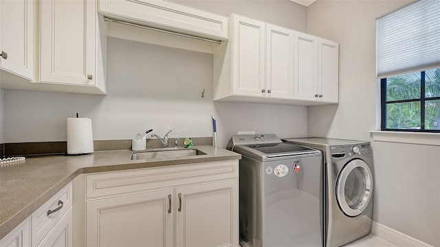 laundry area with baseboards, a sink, cabinet space, and washer and dryer