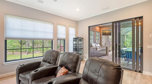 living area featuring ornamental molding, a wealth of natural light, and light wood-style flooring