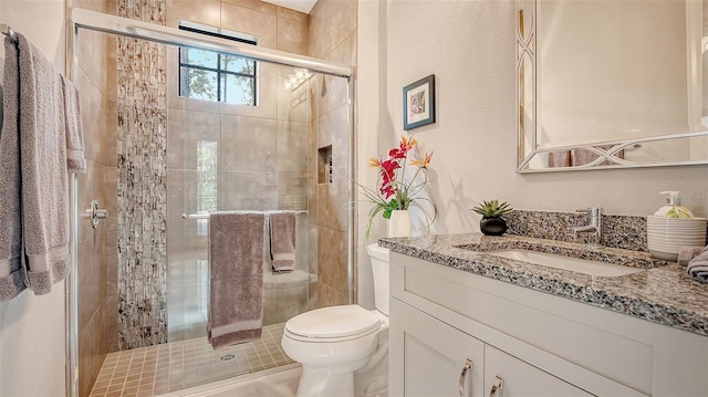 bathroom featuring vanity, toilet, and a shower stall