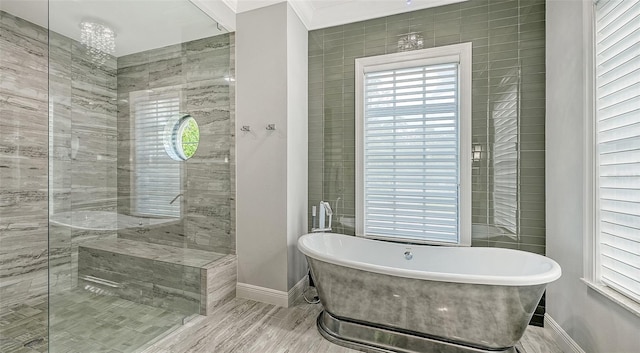 full bath with ornamental molding, a freestanding bath, baseboards, and a walk in shower