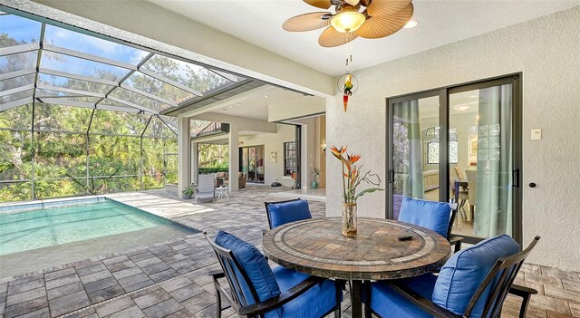 exterior space featuring an outdoor pool, outdoor dining space, a lanai, and ceiling fan