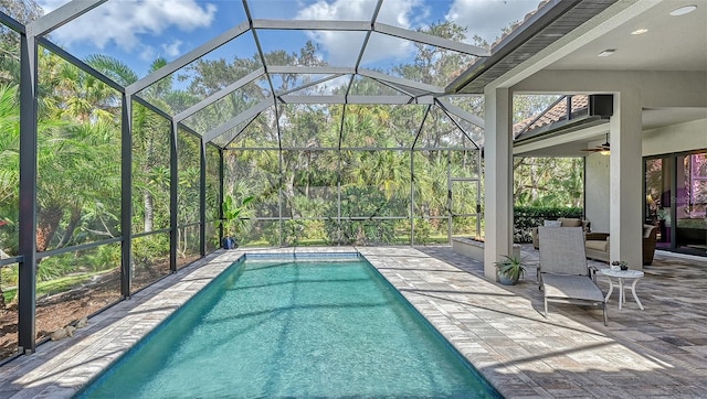 outdoor pool with a patio, a lanai, and a ceiling fan