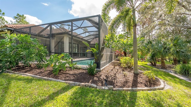 back of house featuring a lanai, a tile roof, an outdoor pool, and a lawn