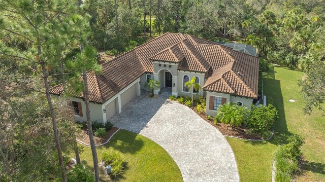 9291 Swaying Branch Rd, Sarasota, FL 34241 - view of front facade with stucco siding, a tile roof, an attached garage, a front lawn, and driveway