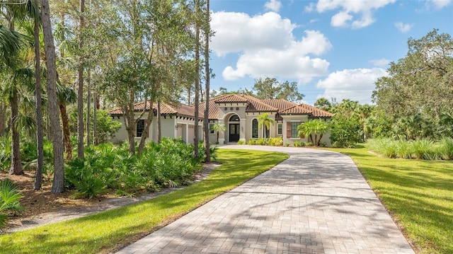 9291 Swaying Branch Rd, Sarasota, FL 34241 - view of front of property featuring decorative driveway, a tile roof, stucco siding, an attached garage, and a front yard