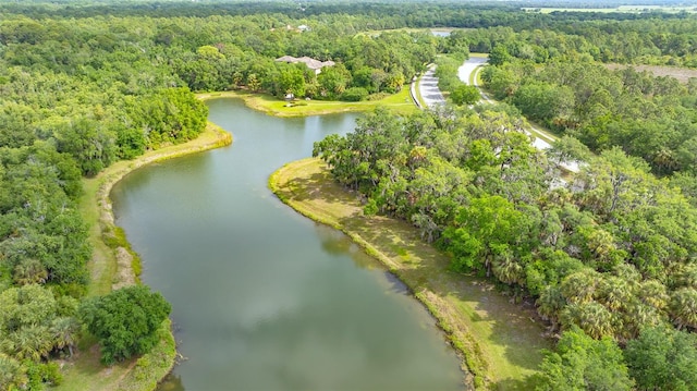 birds eye view of property featuring a water view and a view of trees