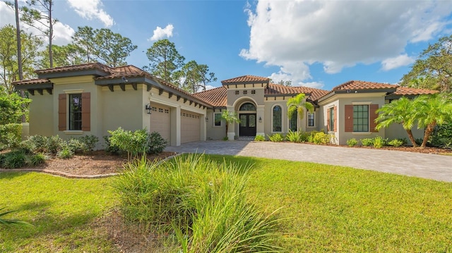 mediterranean / spanish-style home featuring a garage, a front yard, decorative driveway, and a tiled roof