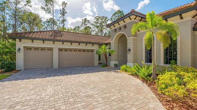9291 Swaying Branch Rd, Sarasota, FL 34241 - mediterranean / spanish-style house with a tiled roof, stucco siding, driveway, and an attached garage